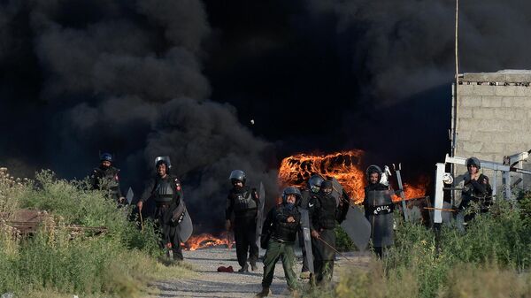 Полицейские бросают камни в сторону сторонников бывшего премьер-министра Пакистана Имрана Хана во время столкновений (10 мая 2023). Исламабад - Sputnik Армения