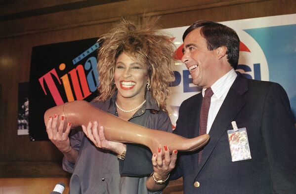 Тина Тернер получает &quot;шоколадную ногу&quot; от президента Pepsi Роджера Энрико 1985 год - Sputnik Армения