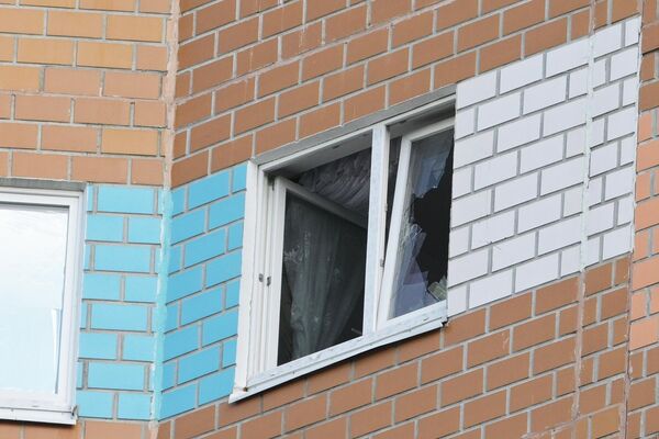Разбитое окно жилого дома, пострадавшего в результате атаки беспилотника, на улице Профсоюзная в Москвеце. - Sputnik Армения