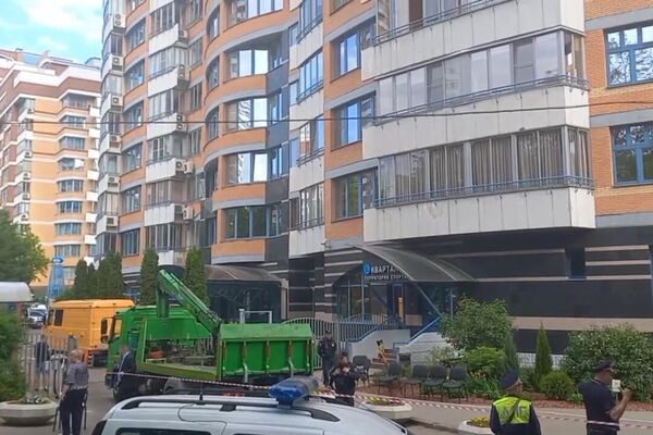 Сотрудники экстренных служб работают у жилого дома, пострадавшего в результате атаки беспилотника, на Ленинском проспекте в Москве - Sputnik Армения
