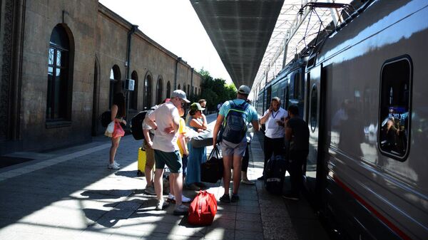 Пассажиры на платформе у поезда ЮКЖД - Sputnik Армения