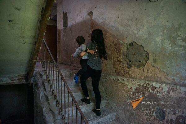 Արցախի պողոտայի 4-րդ նրբանցքի վթարային շենքի բնակչուհին մանկահասակ երեխայի հետ - Sputnik Արմենիա