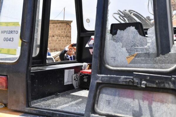 Дипломаты осматривают и фотографируют поврежденный трактор.  - Sputnik Армения