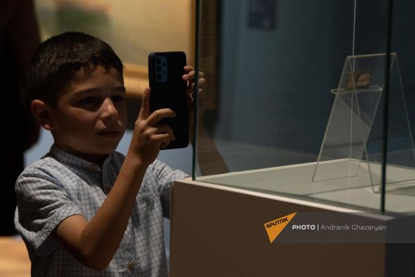 Տղան լուսանկարում է Հայաստանի ազգային պատկերասրահում ցուցադրության հանված  կտավներից մեկը  - Sputnik Արմենիա