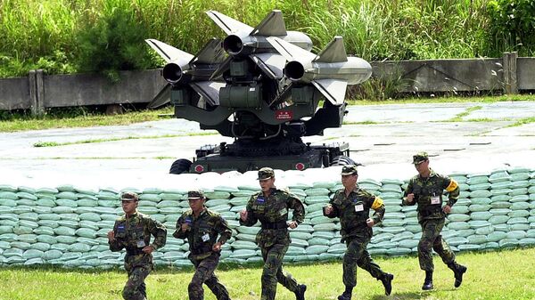 Тайваньские солдаты пробегают мимо трех ракет американского производства Hawk класса земля-воздух, установленных на пусковую установку (10 мая 2002). Чиупенг - Sputnik Армения