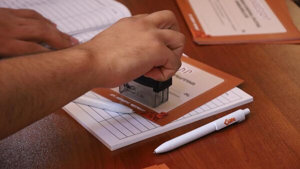 Волонтер ставит штамп на сертификат участника Айакве - Sputnik Армения