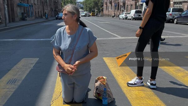 Женщина встала на колени во время акции родных пропавших без вести, перекрывших перекресток Баграмяна - Прошяна (26 июля 2023). Еревaн - Sputnik Армения