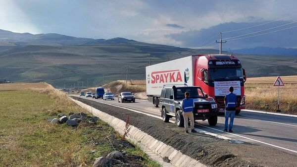 Наблюдатели гражданской миссии ЕС во главе с Маркусом Риттером следят за движением колонны грузовиков с гуманитарной помощью из Армении в НКР у Лачинского коридора со стороны Армении (26 июля 2023). Сюник - Sputnik Արմենիա