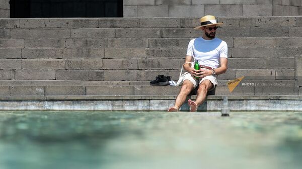Мужчина охлаждает ноги в прохладной воде городского фонтана (10 аввгуста 2023). Еревaн - Sputnik Армения