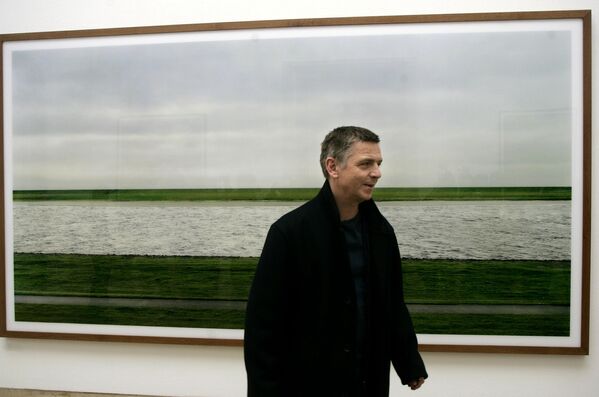 Фотохудожник Андреас Гурски проходит мимо работы &quot;Рейн II 1999&quot; в МюнхенеРаботы Гурски регулярно достигают наивысших цен на аукционах - Sputnik Армения