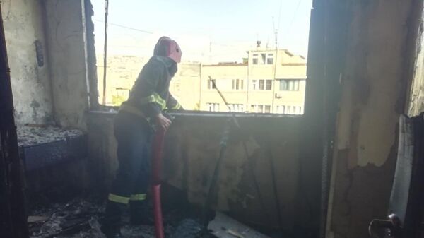 Спасатель на месте пожара в одной из квартир дома №1 по улице Кохбаци (20 августа 2023). Еревaн - Sputnik Армения