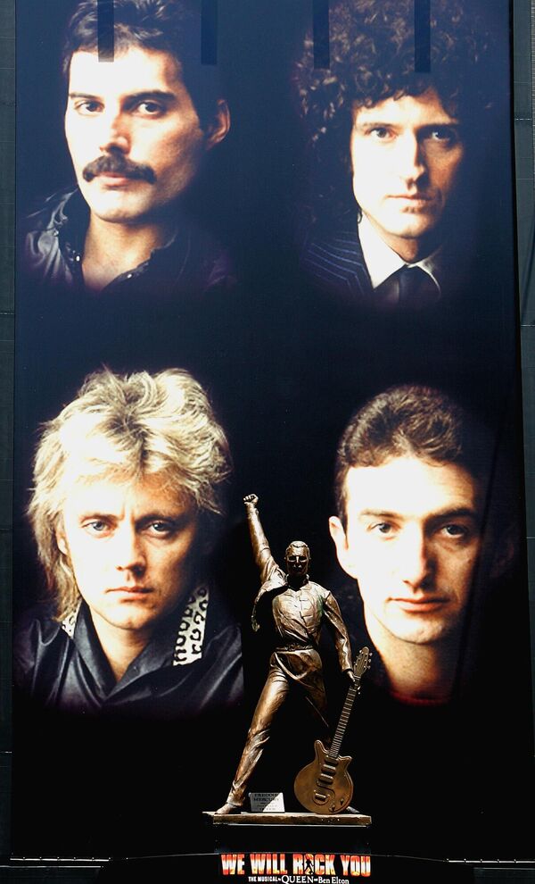 Бронзовая статуя Фредди Меркьюри на фоне плаката британской рок-группы Queen в токийском развлекательном районе Синдзюку. - Sputnik Армения