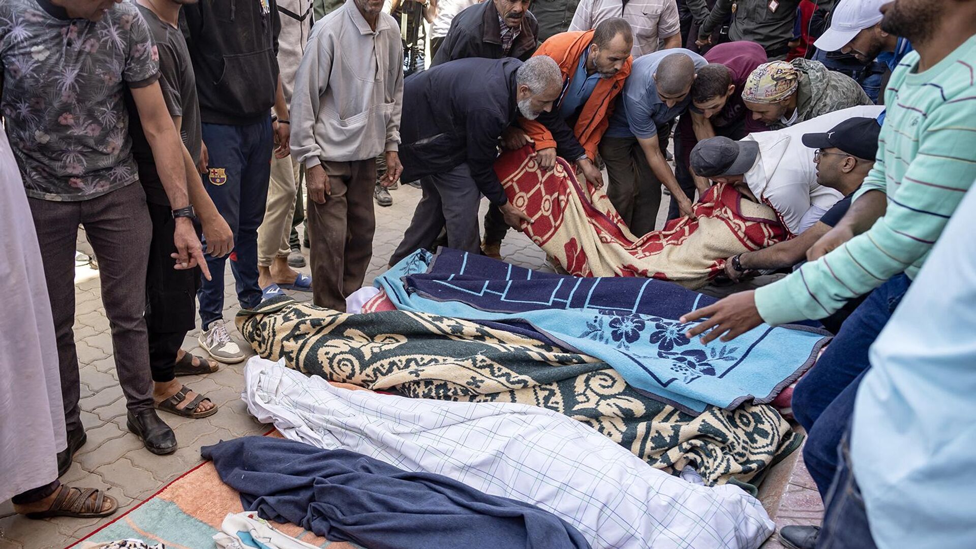 Мужчины выстраивают в ряд тела людей, погибших в результате землетрясения в Мулай Брахиме, провинция Аль-Хауз (9 сентября 2023). Марокко - Sputnik Армения, 1920, 12.09.2023