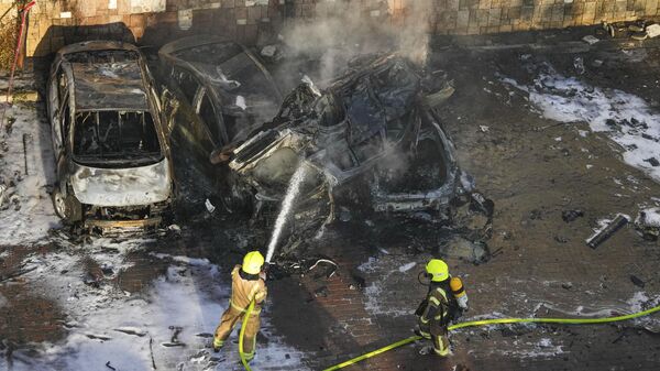 Израильские пожарные тушат автомобили, поврежденные в результате атаки Палестины 7 октября 2023 года - Sputnik Армения