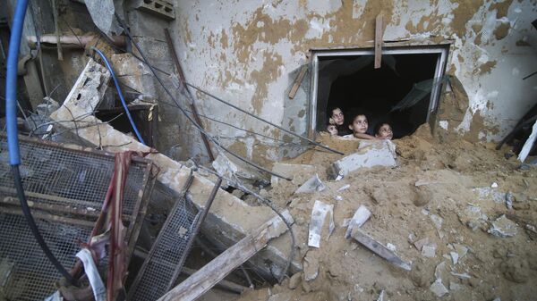 Палестинские дети выглядывают из-под руин разрушенного здания в результате израильских авиаударов в Рафахе, сектор Газа - Sputnik Армения