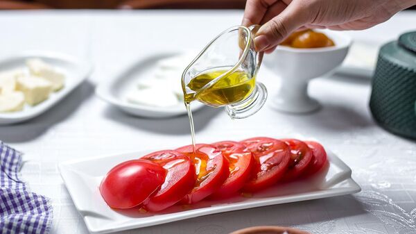 Женщина поливает помидоры оливковым маслом - Sputnik Արմենիա
