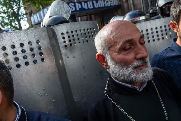 Священник перед отделением полиции, где предположительно находится Никол Пашинян (22 апреля 2018). Ереван - Sputnik Армения
