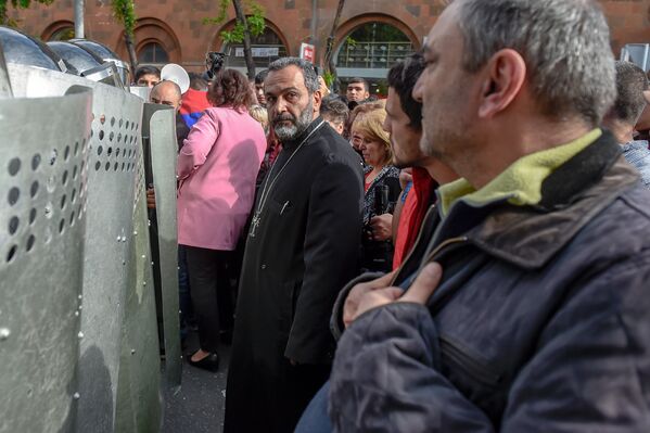 Священник перед отделением полиции, где предположительно находится Никол Пашинян (22 апреля 2018). Ереван - Sputnik Армения