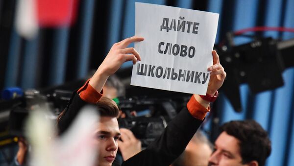 Табличка в руках журналиста во время ежегодной большой пресс-конференции президента России Владимира Путина (20 декабря 2018). Москвa - Sputnik Армения