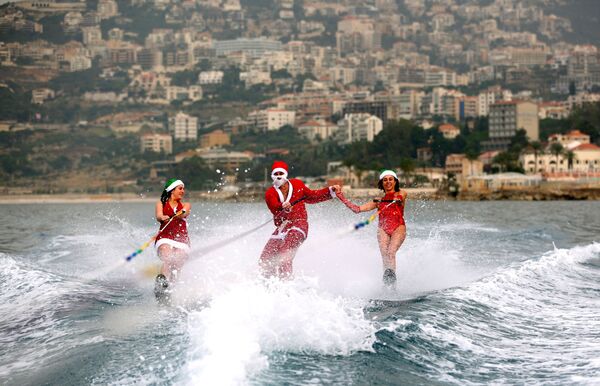 Молодые люди на водных лыжах в костюмах Санта-Клаусов в заливе Джуния, Ливан - Sputnik Армения
