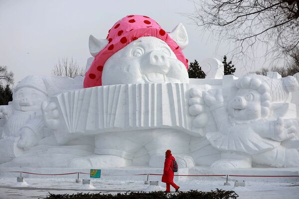 Посетитель около снежной скульптуры свиньи в парке города Харбин (4 января 2019). Китай - Sputnik Армения