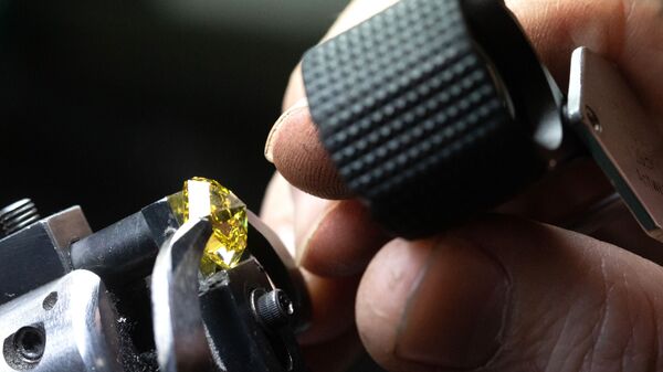 Сотрудник рассматривает бриллиант в цехе огранки ООО Бриллианты Алроса в Москве - Sputnik Армения