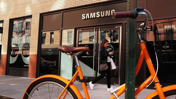 Женщина со смартфоном проходит мимо магазина Samsung в Нижнем Манхэттене (11 октября 2016). Нью-Йорк - Sputnik Արմենիա