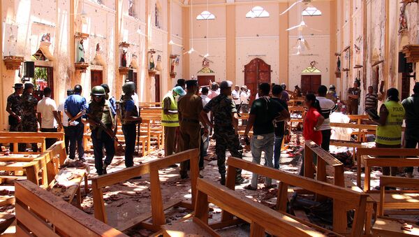 Сотрудники Службы безопасности Шри-Ланки проходят через обломки после взрыва в церкви Святого Себастьяна в Негомбо, к северу от столицы Коломбо (21 апреля 2019). Шри-Ланка - Sputnik Армения