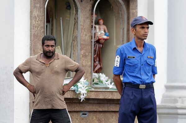 Сотрудник полиции Шри-Ланки и местный житель перед святыней Святого Антония в Коломбо, где произошел взрыв (21 апреля 2019). Шри-Ланка - Sputnik Армения