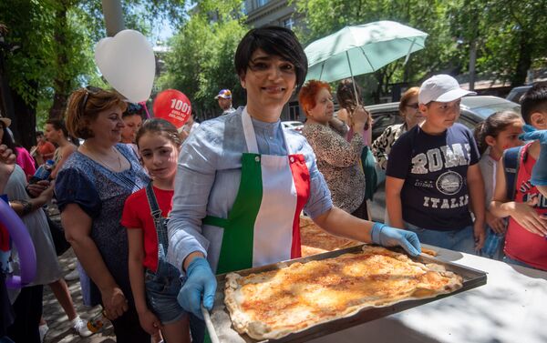 Директор отдела маркетинга и продаж компании Тория Карта Сиран Абаджян за приготовлением самой длинной пиццы в Армении (1 июня 2019). Еревaн - Sputnik Армения