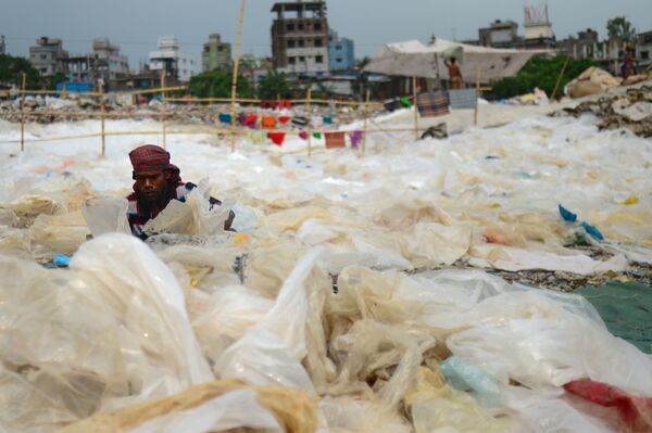 Мужчина сортирует пластик в Дакке, Бангладеш - Sputnik Армения