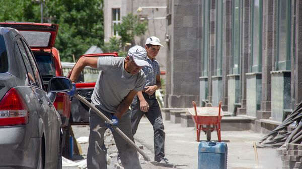 Рабочий за укладкой дорожной плитки на улице Арама (9 июня 2019). Еревaн - Sputnik Армения