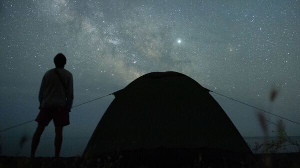 Мужчина наблюдает за звездным небом на берегу Черного моря возле поселка Морское в Крыму - Sputnik Армения