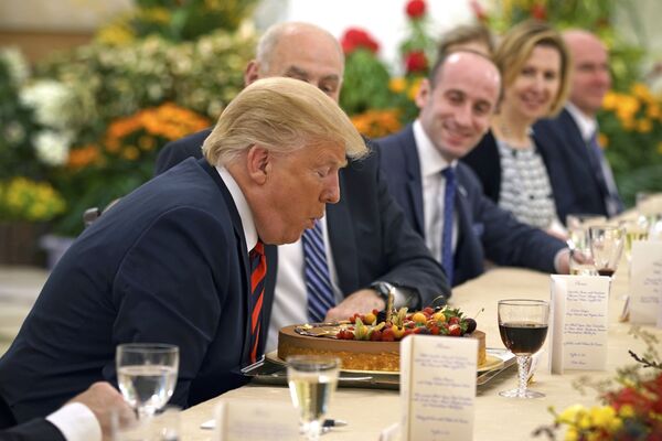 Президент США Дональд Трамп задувает свечу на торте в свой день рождения во время встречи с премьер-министром Сингапура Ли Сянлуном - Sputnik Армения