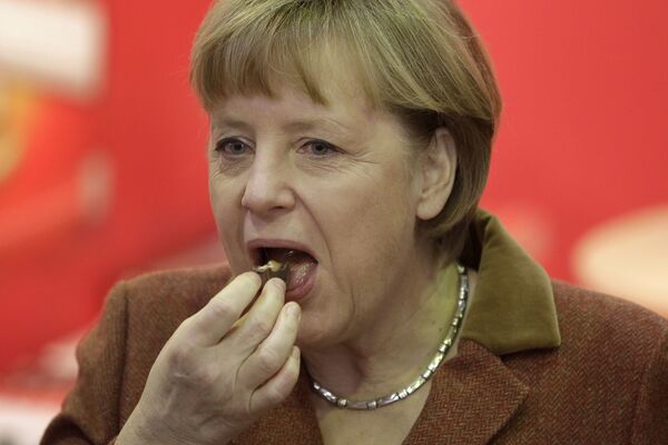 Канцлер Германии Ангела Меркель во время поедания кусочка шоколада - Sputnik Армения