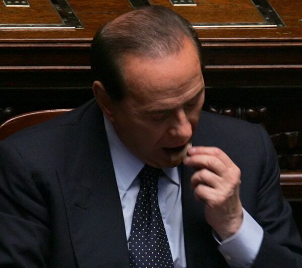 Премьер Италии Сильвио Берлускони ест кусочек шоколада в Риме, 2005 год - Sputnik Армения
