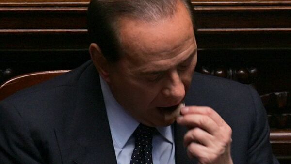 Премьер Италии Сильвио Берлускони ест кусочек шоколада в Риме, 2005 год - Sputnik Армения