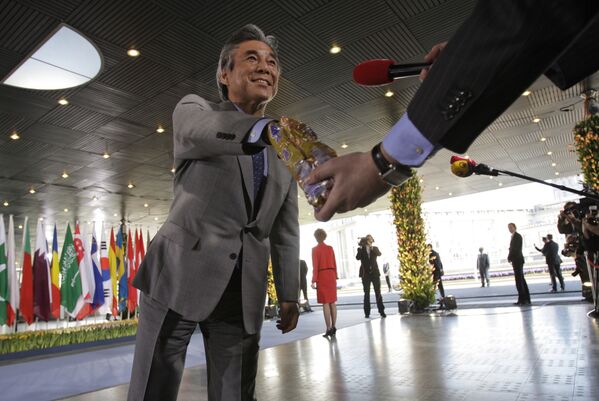Министр иностранных дел Японии Хирофуми Накасонэ берет шоколадку из пакета репортера голландского телеканала на конференции в Гааге, Нидерланды - Sputnik Армения