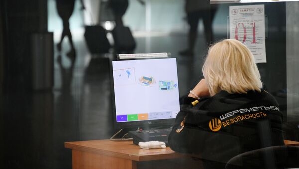 Сотрудник службы безопасности во время проверки багажа в аэропорту Шереметьево. - Sputnik Армения