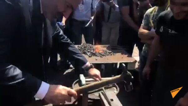 Премьер министр Армении Никол Пашинян мастерит металлическое изделие на выставке - Sputnik Армения