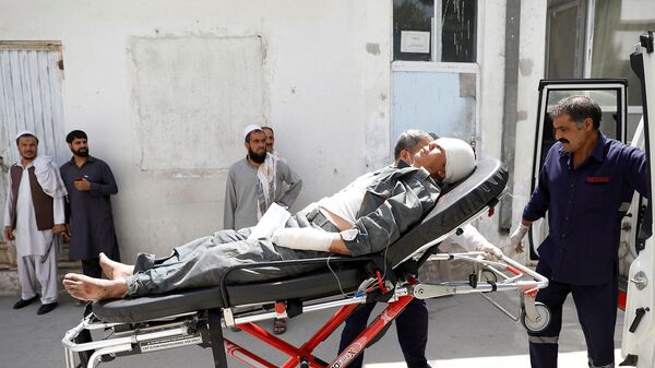 Спасатели помогают раненого мужчину после взрыва в Кабуле (7 августа 2019). Афганистан - Sputnik Армения