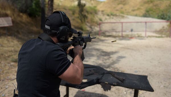 Раввин Разиэль Коэн, он же тактический раввин, стреляет из полуавтоматической винтовки AR-15 во время демонстрации на стрельбищах Анджелеса (20 мая 2019). Пакоймa - Sputnik Արմենիա