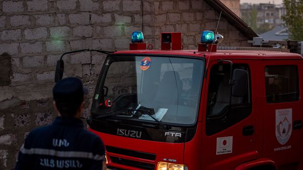 Сотрудник МЧС Армении у пожарного автомобиля - Sputnik Армения