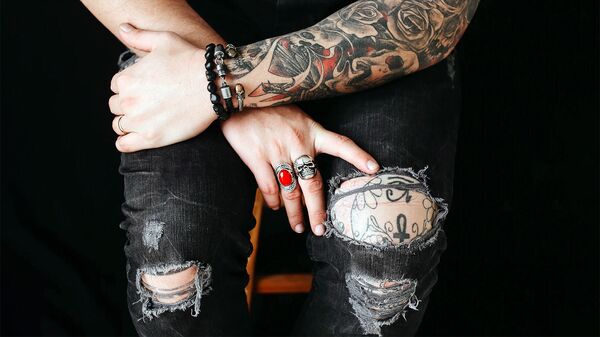 Молодой человек с татуировками в потертых джинсах - Sputnik Արմենիա