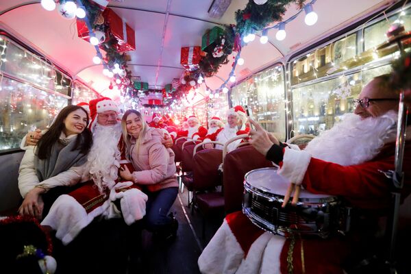 Музыканты в костюмах Санта-Клауса в автобусе в Санкт-Петербурге  - Sputnik Армения
