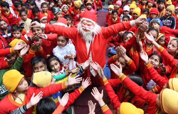 Девушка в костюме Санта-Клауса раздает подарки детям в Индии  - Sputnik Армения