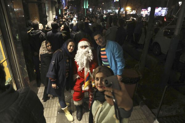 Жители во время фотографирования с Санта-Клаусом в Тегеране  - Sputnik Армения