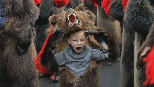 Зевающий мальчик в костюме медведя на новогоднем шествии в румынском городе Комэнешти - Sputnik Армения