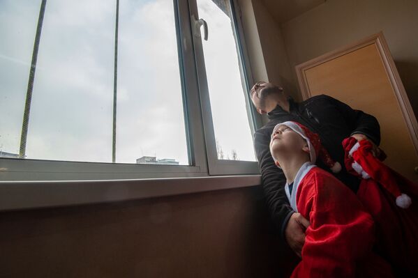 Բուժկենտրոնի պատուհանների մոտ հետևում են ալպինիստ Ձմեռ պապերին - Sputnik Արմենիա