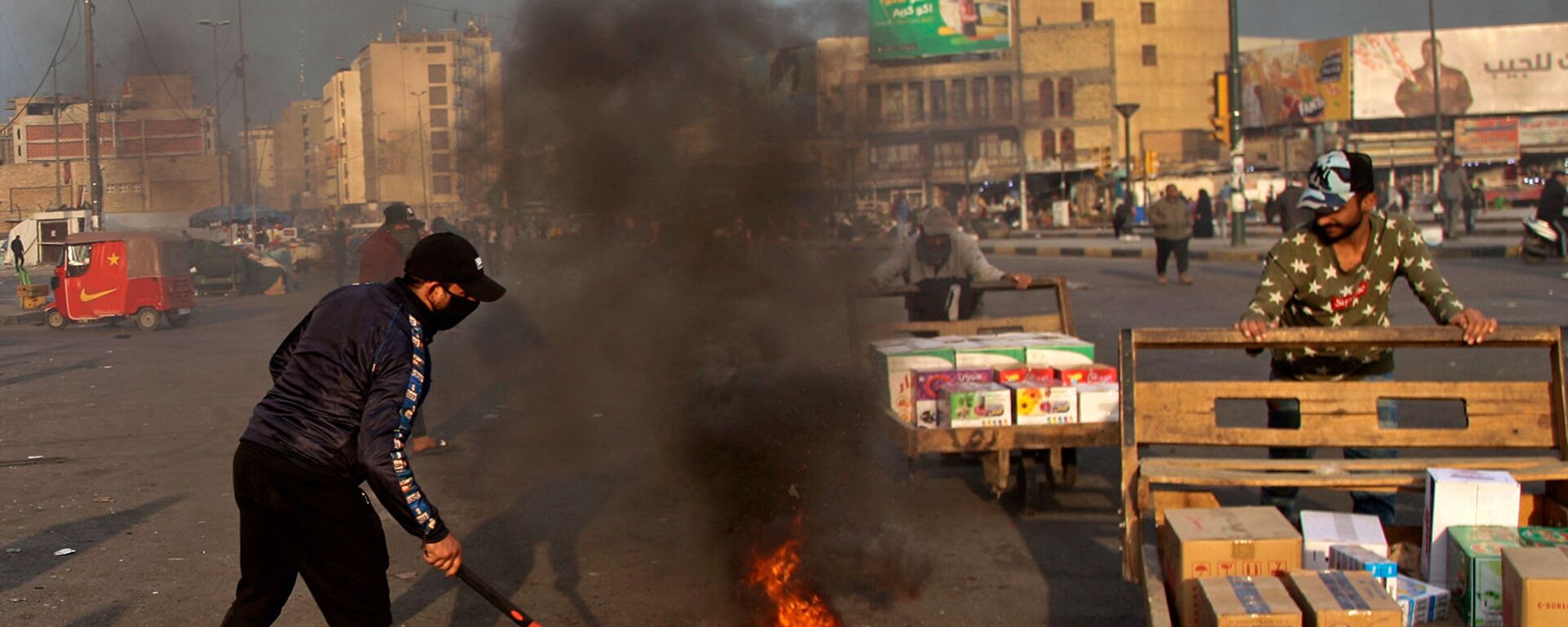 Протестующие устроили поджоги, чтобы закрыть улицы возле площади Тахрир во время демонстрации протеста против иранского ракетного удара (8 января 2020). Багдад - Sputnik Армения, 1920, 22.07.2021